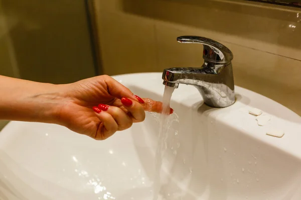 Händewaschen unter Wasser aus dem Wasserhahn. Schlankheit, Wassereinsparung, Geschirrspülen in einem hellen skandinavischen Interieur — Stockfoto