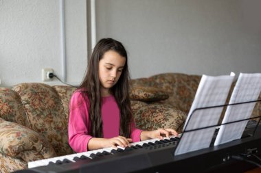 little girl playing on a new synthesizer in the old room