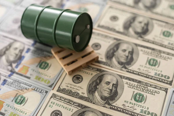 Barris de petróleo nas notas de dinheiro do dólar. o negócio do petróleo, venda de compra, produção, troca, renda comercial. — Fotografia de Stock