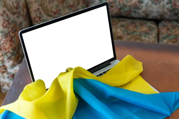 A tela em branco laptop no fundo da bandeira da Ucrânia. espaço de cópia — Fotografia de Stock
