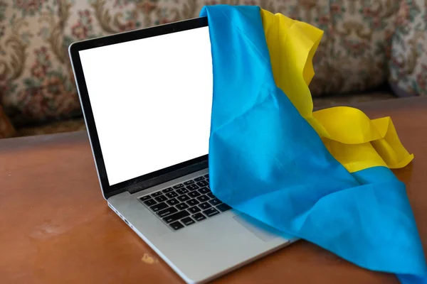 Ноутбук-макет на фоне украинского желто-синего флага. — стоковое фото