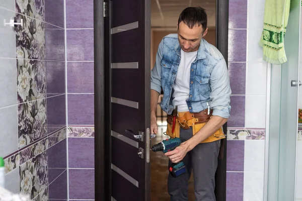 Handyman fixing or repairing apartment wooden door lock. home furniture adjusting. door repair concept. — Stock Photo, Image