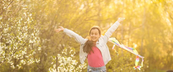 Menina voando um papagaio correndo ao ar livre com um papagaio — Fotografia de Stock