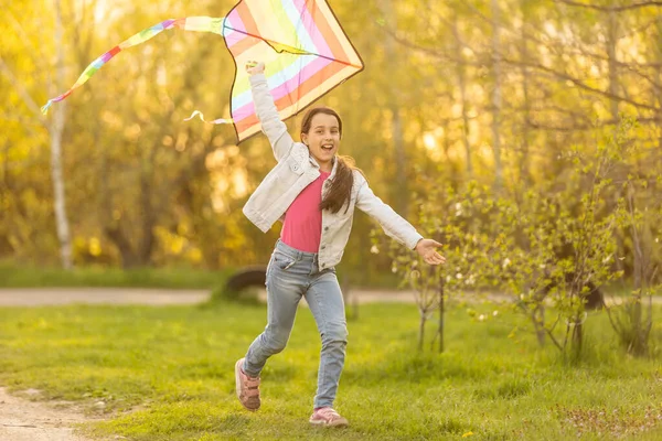 Happy child girl with a kite running on meadow in nature. — стоковое фото
