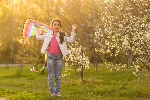 Happy child girl with a kite running on meadow in nature. — стоковое фото