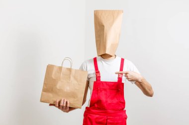 Kafasında paketler olan yemek teslimatı yapan adam.