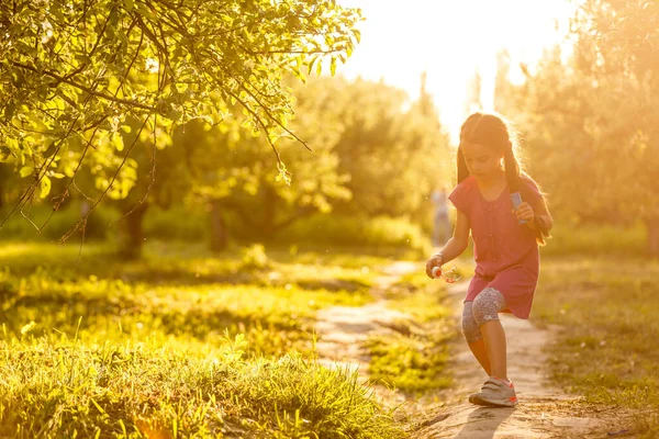 五岁白人儿童女孩吹肥皂泡泡室外日落-快乐无忧无虑的童年. — 图库照片
