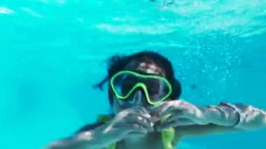 Gözlüklü mutlu kız havuzda suyun altında yüzer. Kapat..