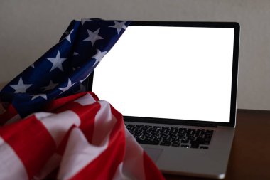 Boş ekranlı dizüstü bilgisayar ve ofiste ABD bayrağı