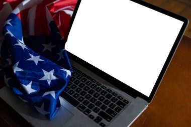 Boş ekranlı dizüstü bilgisayar ve ofiste ABD bayrağı