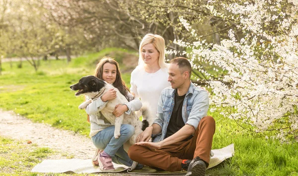 Família em um jardim de primavera florescendo. Conceito de família feliz — Fotografia de Stock
