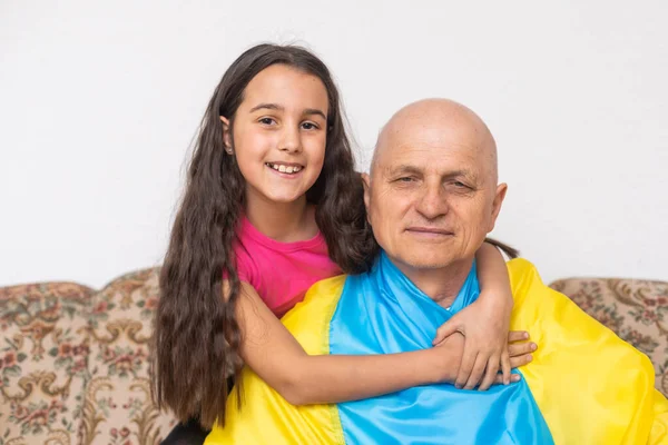 Elderly man and girl with the flag of Ukraine — Stock Photo, Image