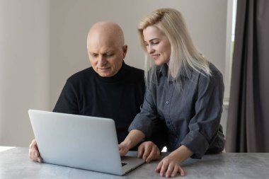 Ön manzara mutlu 70 'li yaşlılar gri saçlı adam bilgisayar yazılımı kullanarak yetişkin kız, emekli yaşlı insanlar ve modern teknoloji kavramını öğreniyor.