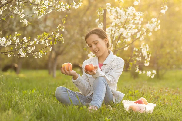 Усміхнена дівчина в сорочці з квітучим садом навесні . — стокове фото