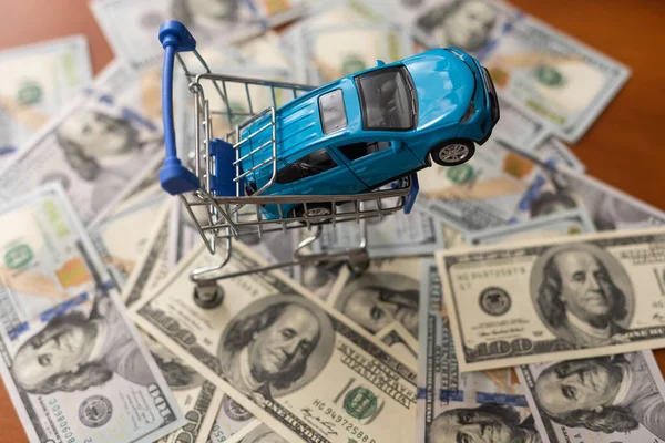 Carro de brinquedo em notas de cem dólares. — Fotografia de Stock