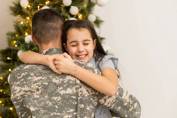 Soldier in uniform with his daughter. An off duty military man spending Christmas holiday with his family at home. — Fotografia de Stock