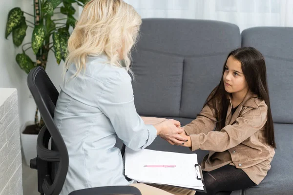 Kvinnlig skolpsykolog kommunicerar med en skolflicka — Stockfoto