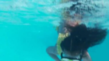 Gözlüklü mutlu kız havuzda suyun altında yüzer. Kapat..