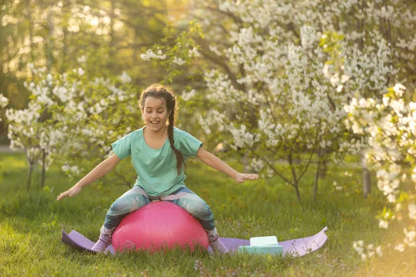 Güzel kız yoga egzersizleri yapıyor, küçük kız bahçede yoga egzersizleri yapıyor..