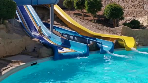 Kind op Wasser Rutsche op aquapark. zomervakantie. — Stockvideo