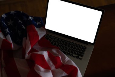 Boş ekranlı dizüstü bilgisayar ve ofiste ABD bayrağı