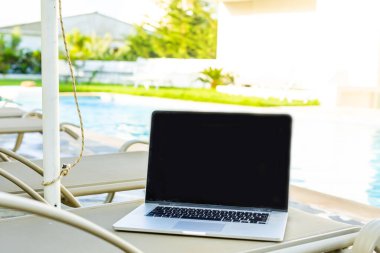 Havuz kenarında güneşlenen bir bilgisayarda.