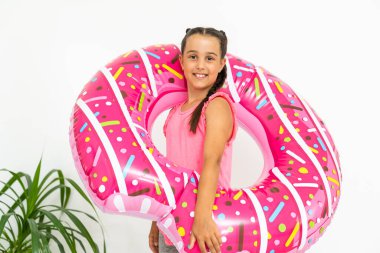 Sevimli küçük kız büyük pembe lastik yüzükle eğleniyor, yaz tatillerini geçiriyor.