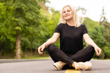 Çekici genç bir kadın yol boyunca yürür ve doğanın tadını çıkarır..