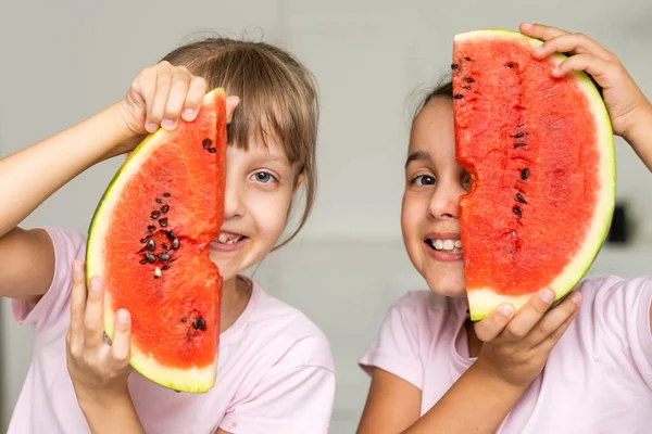 Двоє дітей їдять один шматочок кавуна. Діти їдять фрукти на відкритому повітрі. Здорові закуски для дітей . — стокове фото