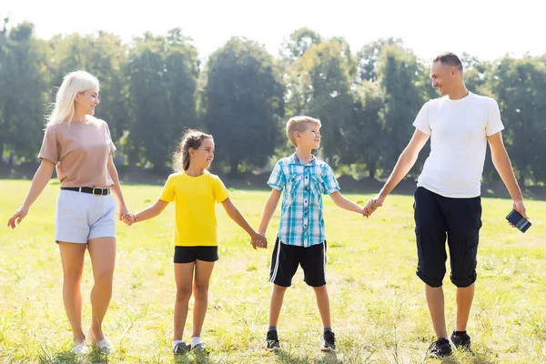 Família feliz desfrutando a vida juntos no prado ao ar livre. — Fotografia de Stock