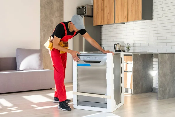Maestro instalando el lavavajillas en un armario de cocina —  Fotos de Stock