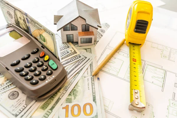 Miniature model of house against the background of a house plan, and money, and calculator. — Stock Photo, Image