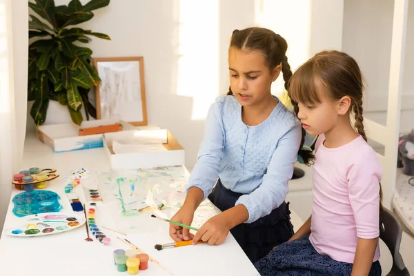 Mutlu çocuk gülüyor. Neşeli küçük kızlar Ressam bir resim çizer