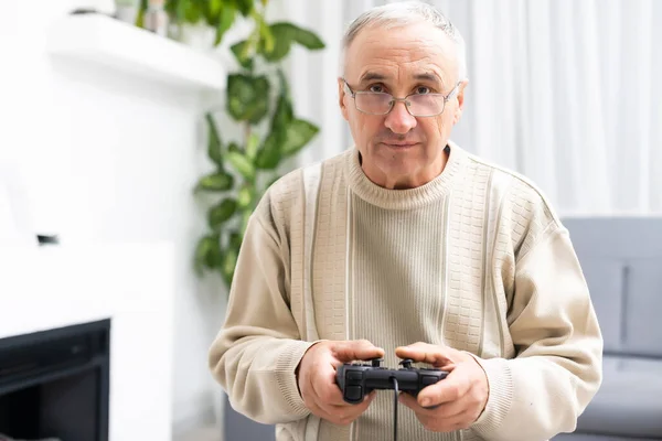 Portret van een oudere man die videospelletjes speelt met een joystick — Stockfoto