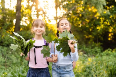 Güneşli bir sonbahar gününde bir parkta birlikte poz iki sevimli gülümseyen 8 yaşındaki kız. Dostluk kavramı.
