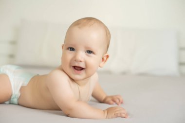 Beyaz yatak odasındaki sevimli erkek bebek. Yeni doğmuş çocuk yatakta dinleniyor. Aile sabahı evde..