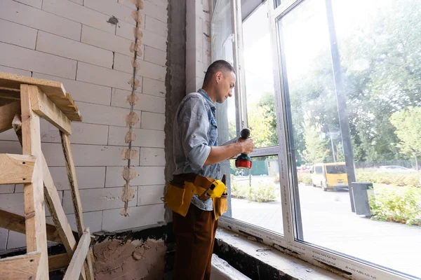Male worker installing window in flat, closeup