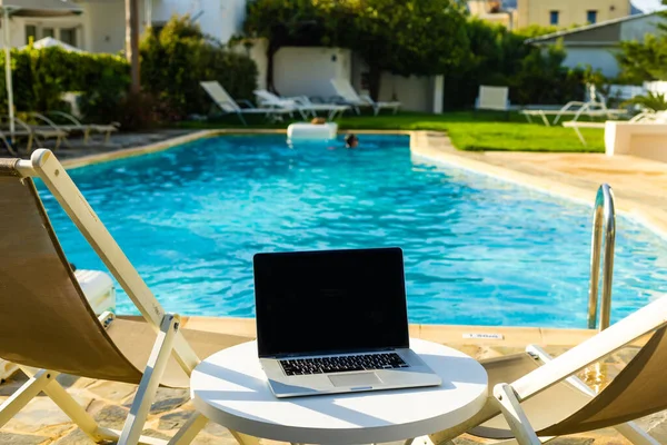 Laptop computer on table pool background — Stock Photo, Image
