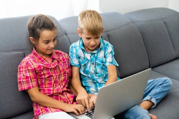 Діти грають з портативним комп'ютером вдома — стокове фото