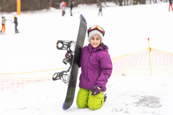 Little Cute Girl Snowboard en la estación de esquí en el soleado día de invierno. — Foto de Stock