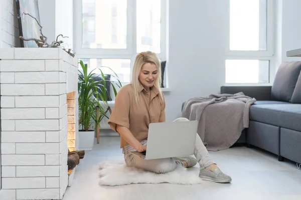A aproveitar o tempo em casa. Bela jovem sorrindo mulher trabalhando no laptop em casa — Fotografia de Stock