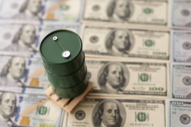 Dolar banknotlarının üzerinde duran variller dolusu petrol. Petrol işi, satış, üretim, takas, ticaret geliri.