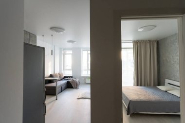 Modern minimalist koyu gri çatı katı tarzı stüdyo daire iç tasarımı. Mutfak, oturma alanı, iş yeri