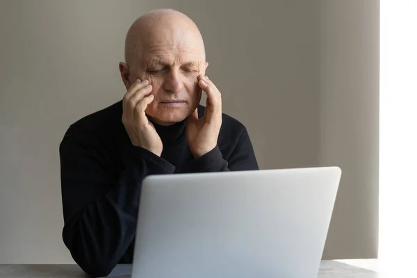 Worried senior man using laptop at home — Stock Photo, Image