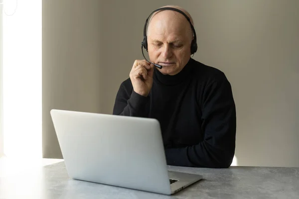 Close up of modern elderly man sit at home having online consultation with doctor on computer, sick senior male talk on video call consulting with female nurse using laptop, healthcare concept.