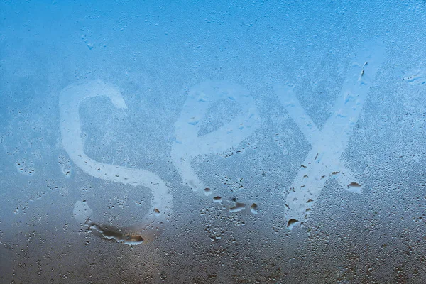 Крупним планом знак сексу на туманному склі вікна з краплями конденсованого фону, чуттєва парна абстракція — стокове фото