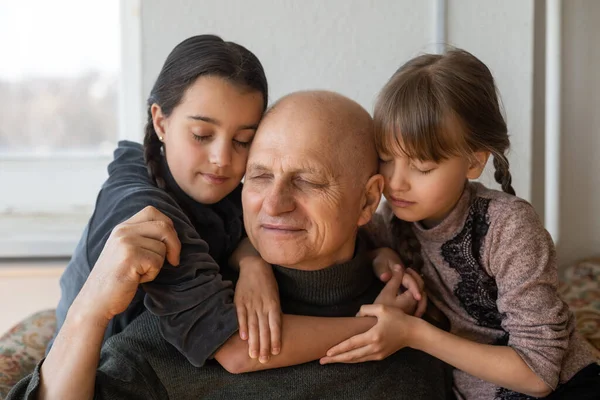 Український дід і дві онуки обіймаються. — стокове фото