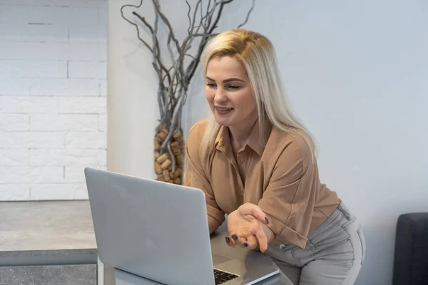 Woman in a cozy interior using a laptop. Womens hobby, searching for references and materials, learning