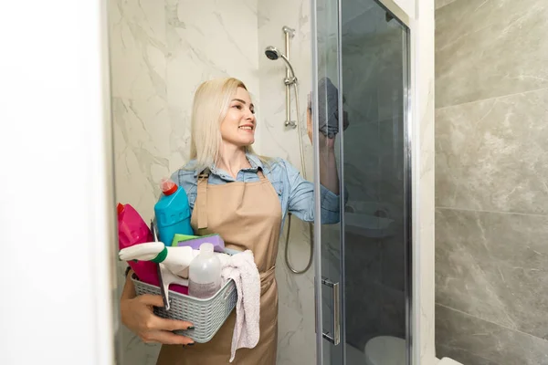Kobieta z czyszczenia sprzęt gotowy do czyszczenia domu na tle łazienka. — Zdjęcie stockowe