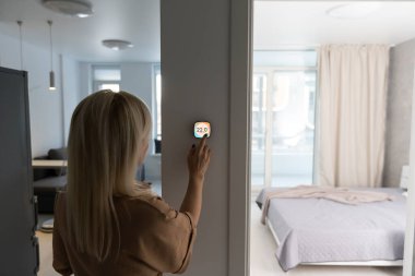 Evinde güzel mutlu kadın basma düğmesi dijital termostat